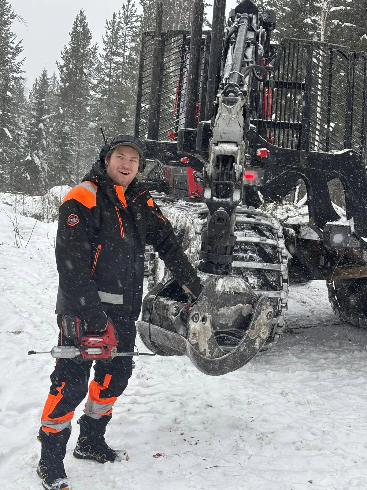 Leende förare i arbetskläder vid skotarens grip i snön